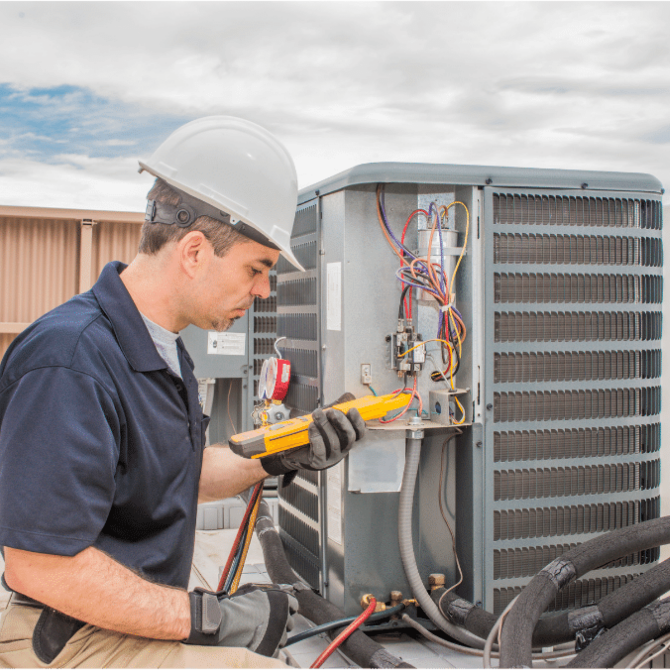 Elmira Heating & Cooling HVAC technician servicing a system